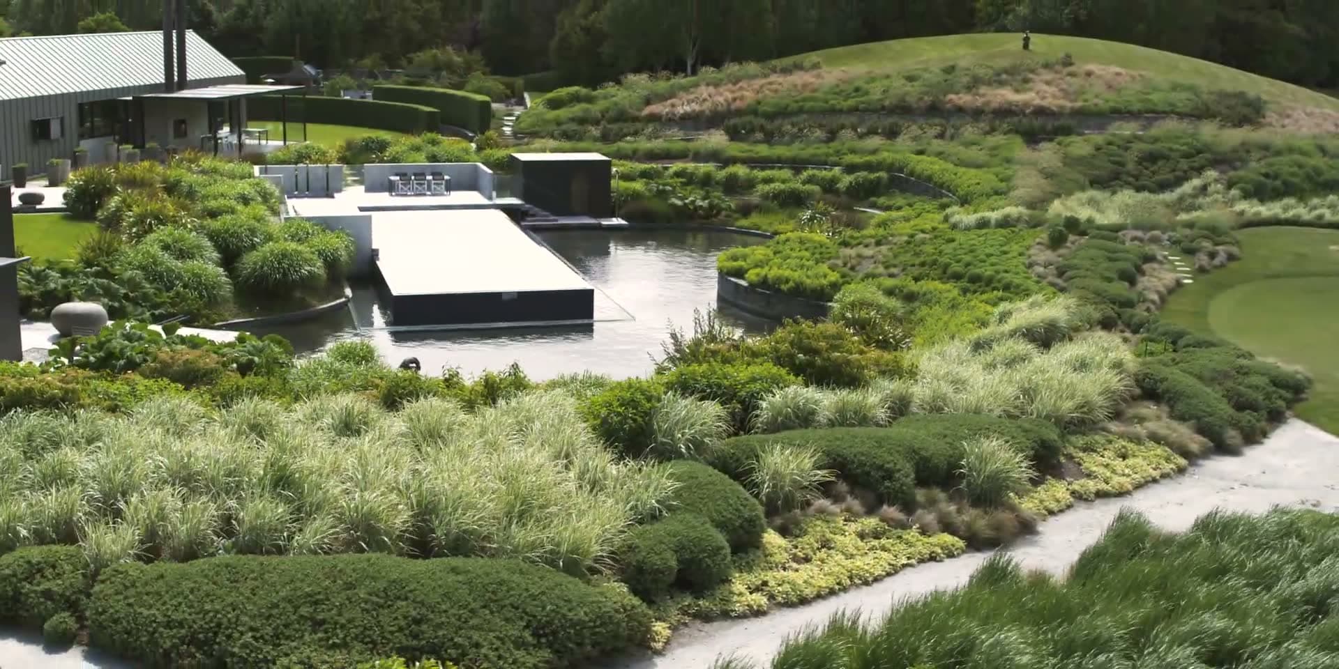 The garden at The Lodge at The Hills, with its pond, terraced planting and paths